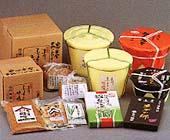 いろいろな種類の箱詰めされた味噌と樽味噌、袋詰めの味噌などが並べられた写真