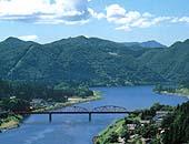 麒麟山展望台からみた阿賀野川と麒麟橋。その奥の山々と青い空の風景写真